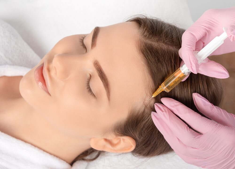 Woman receiving a cosmetic exosome injection with gloves on a beige background