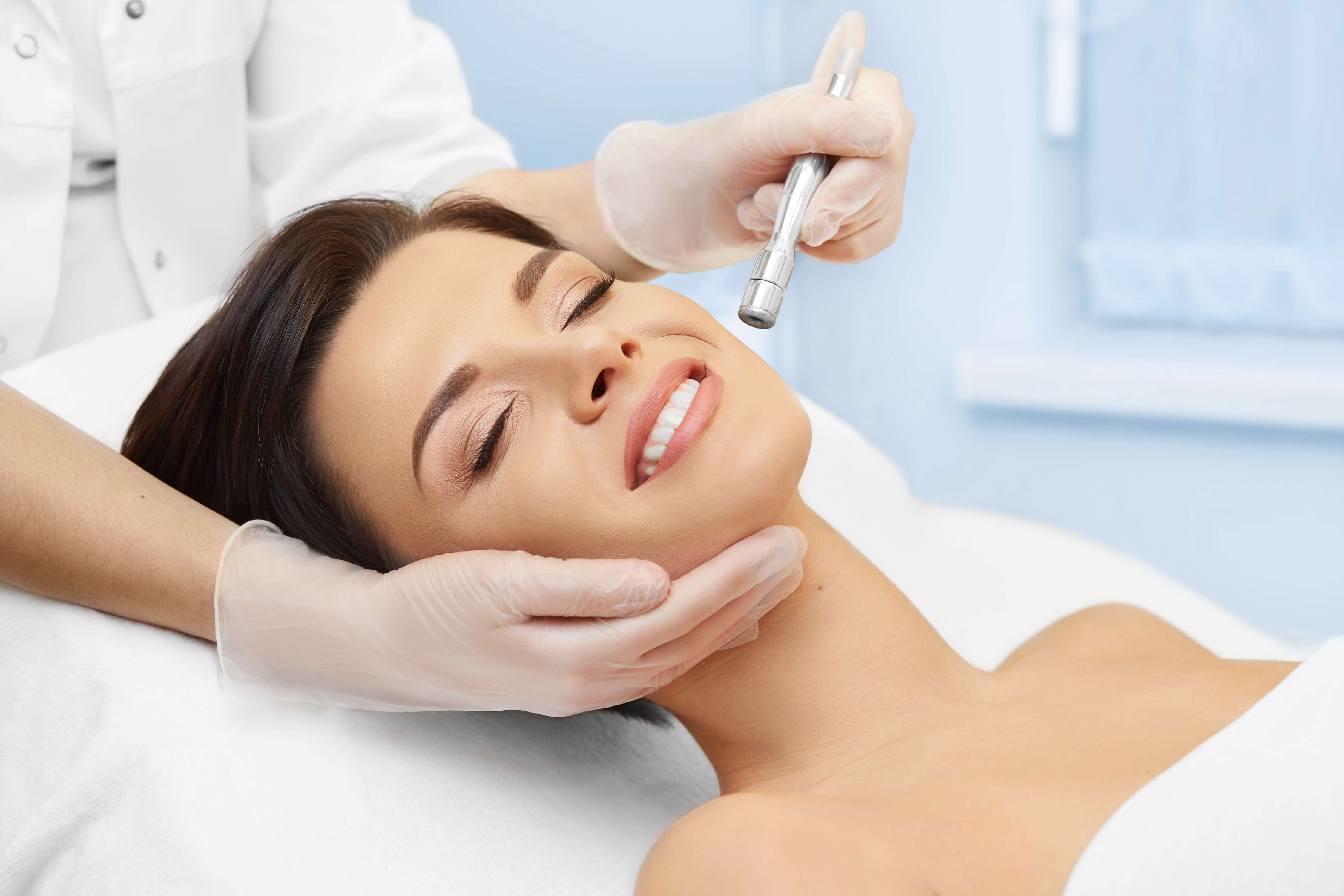 woman receiving microneedling treatment on her face